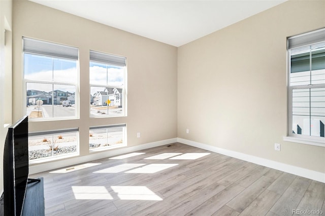 spare room featuring wood finished floors and baseboards