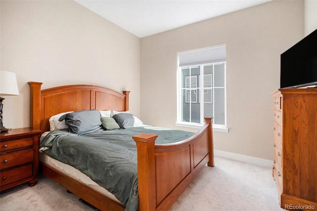 bedroom with light carpet and baseboards