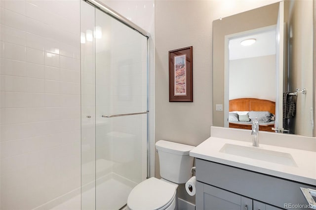 bathroom with toilet, a shower stall, ensuite bath, and vanity