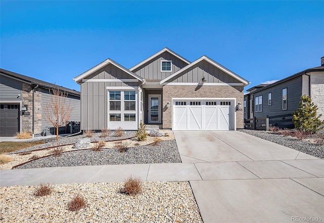 craftsman house featuring driveway, an attached garage, board and batten siding, and brick siding