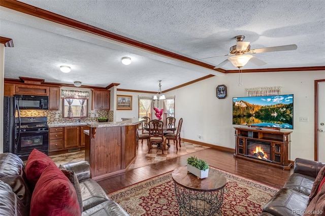 1214 Mac Kay Ct, Dacono, CO 80514 - living area with light wood finished floors, ceiling fan, a textured ceiling, a glass covered fireplace, and ornamental molding