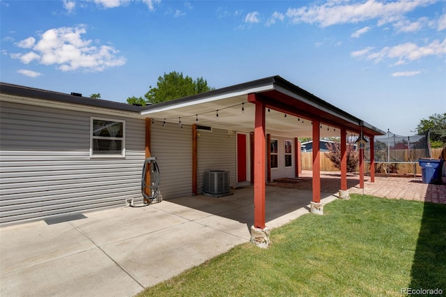 1214 Mac Kay Ct, Dacono, CO 80514 - view of patio / terrace featuring a carport, driveway, and a trampoline