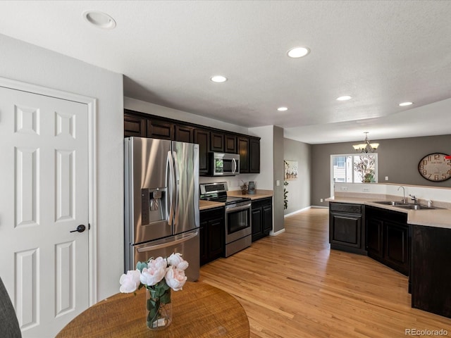 11082 Fillmore Way, Northglenn, CO 80233 - kitchen featuring appliances with stainless steel finishes, light countertops, a chandelier, recessed lighting, and light wood-style flooring