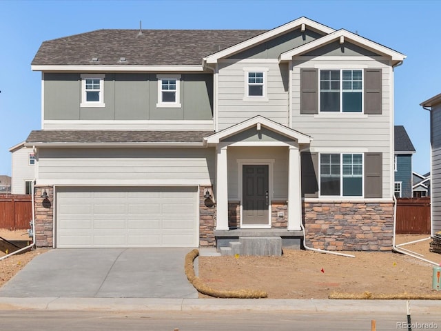 craftsman house featuring stone siding, fence, a garage, and driveway