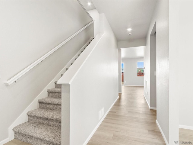 staircase with recessed lighting, visible vents, baseboards, and wood finished floors