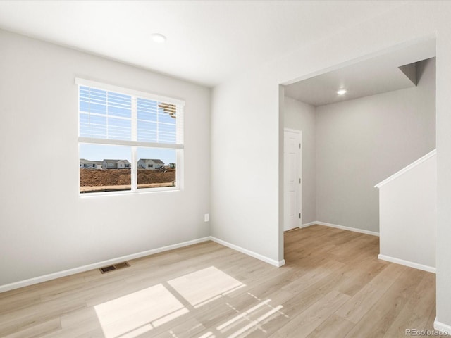 spare room with visible vents, baseboards, and light wood-style floors