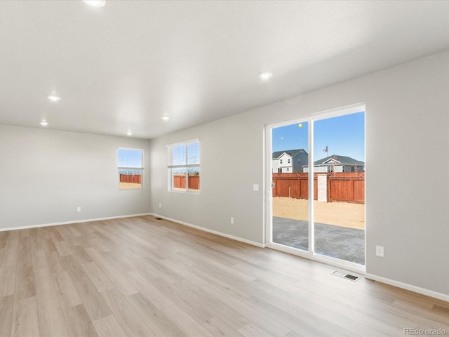 spare room with light wood finished floors, visible vents, recessed lighting, and baseboards