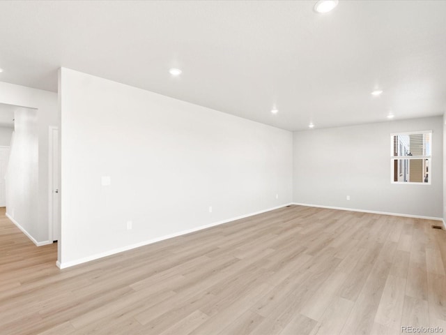 unfurnished room featuring recessed lighting, light wood-style floors, and baseboards