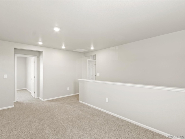 unfurnished room featuring recessed lighting, baseboards, and light carpet