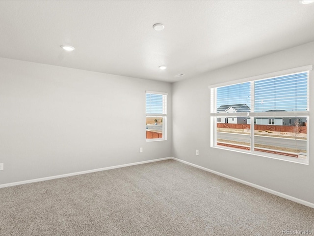 carpeted empty room featuring recessed lighting and baseboards