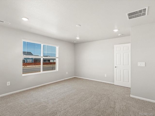 carpeted empty room with recessed lighting, visible vents, and baseboards