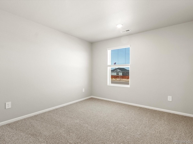 carpeted spare room with baseboards and visible vents