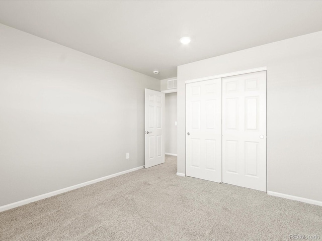 unfurnished bedroom featuring a closet, carpet flooring, visible vents, and baseboards