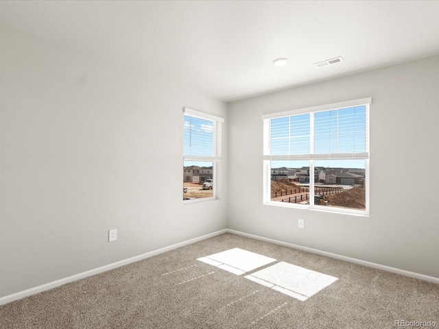 unfurnished room with baseboards, visible vents, and carpet floors