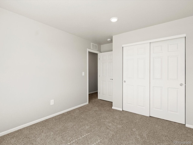 unfurnished bedroom with a closet, baseboards, visible vents, and carpet floors