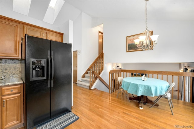 7796 Xavier Ct, Westminster, CO 80030 - dining space featuring lofted ceiling, a chandelier, light wood-style floors, and a skylight