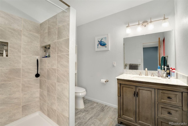 7796 Xavier Ct, Westminster, CO 80030 - bathroom featuring vanity, toilet, a tile shower, and wood finished floors