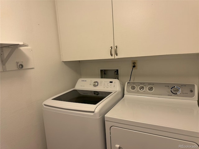 laundry room featuring cabinets and washer and dryer