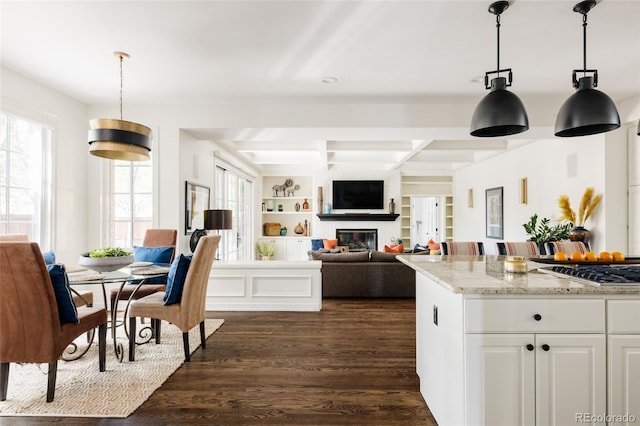 301 Fairfax St, Denver, CO 80220 - kitchen with dark wood-style flooring, stainless steel gas cooktop, a brick fireplace, light stone countertops, and beam ceiling