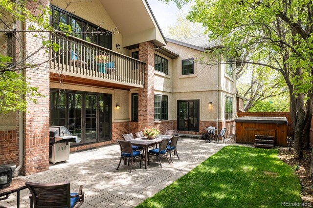301 Fairfax St, Denver, CO 80220 - rear view of property featuring a hot tub, brick siding, stucco siding, and a balcony