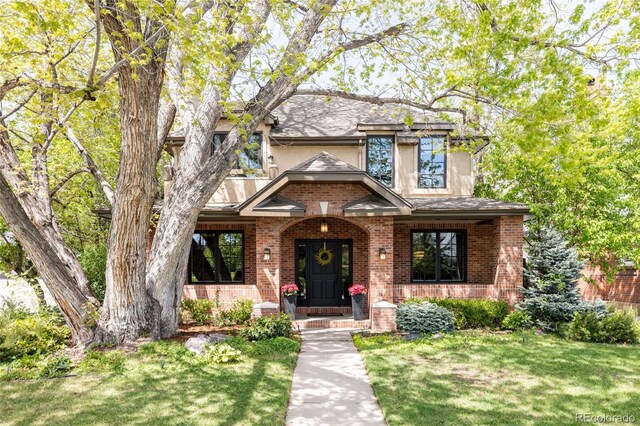301 Fairfax St, Denver, CO 80220 - view of front facade featuring a front lawn, brick siding, covered porch, and stucco siding