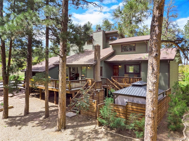 4515 Red Rock Dr, Larkspur, CO 80118 - back of property featuring a chimney, a deck, a shingled roof, and stairway