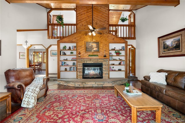 4515 Red Rock Dr, Larkspur, CO 80118 - living room with high vaulted ceiling, a ceiling fan, wood finished floors, a stone fireplace, and baseboards