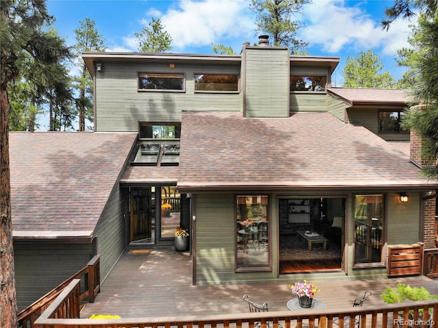 4515 Red Rock Dr, Larkspur, CO 80118 - rear view of house featuring a chimney, a wooden deck, and roof with shingles