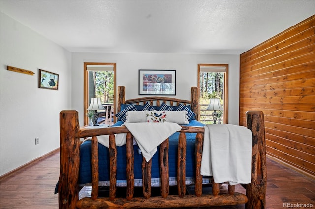 4515 Red Rock Dr, Larkspur, CO 80118 - bedroom with multiple windows, wood finished floors, wooden walls, and baseboards