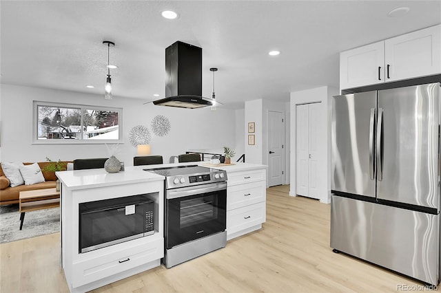 kitchen featuring white cabinetry, hanging light fixtures, light wood-type flooring, appliances with stainless steel finishes, and ventilation hood