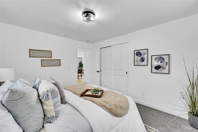 carpeted bedroom with a textured ceiling and a closet