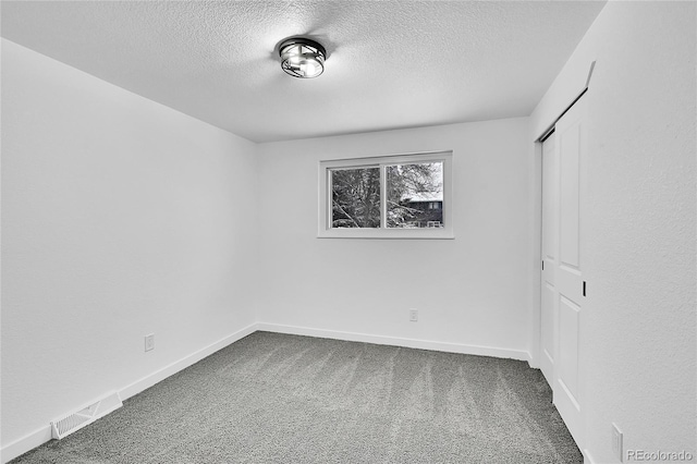 unfurnished bedroom with a textured ceiling, a closet, and carpet floors