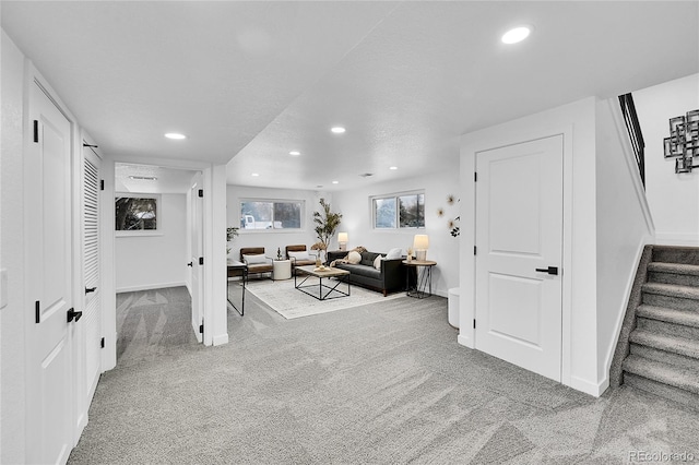 living room featuring a textured ceiling and carpet flooring