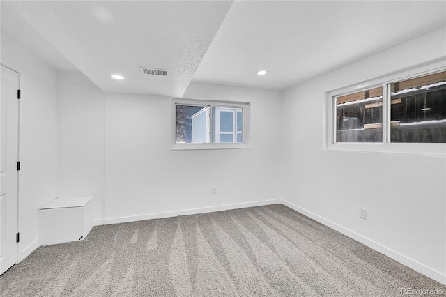 unfurnished room with a textured ceiling and carpet floors