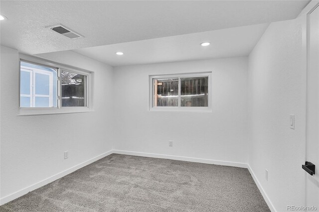 spare room with carpet and a textured ceiling