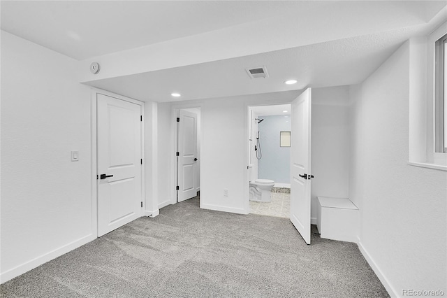 unfurnished bedroom featuring light colored carpet and connected bathroom