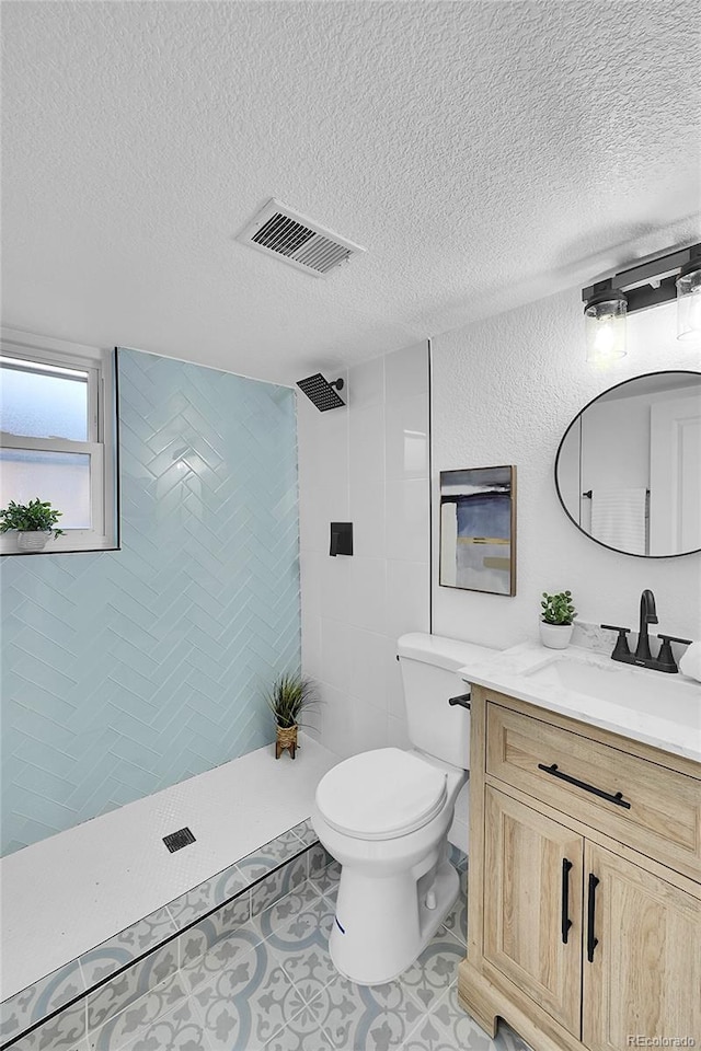 bathroom with toilet, vanity, and a textured ceiling