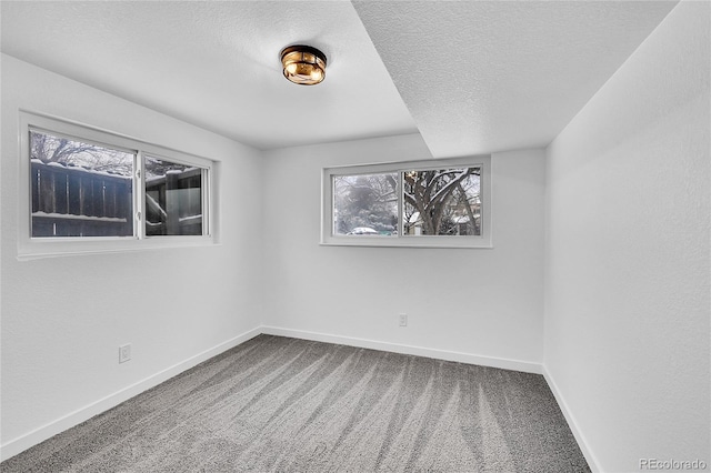 carpeted empty room featuring a textured ceiling