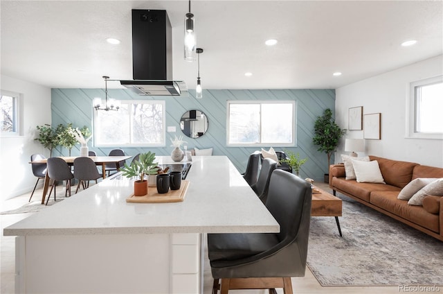 kitchen with an inviting chandelier, decorative light fixtures, and exhaust hood