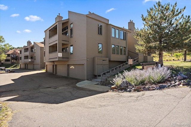 23712 Pondview Pl Unit A, Golden, CO 80401 - view of property with an attached garage, stairway, and asphalt driveway