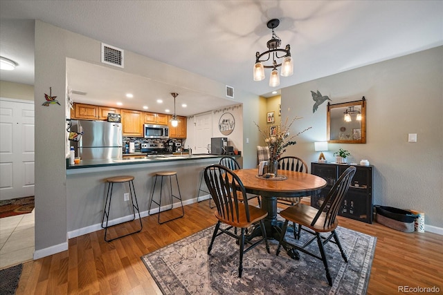 23712 Pondview Pl Unit A, Golden, CO 80401 - dining area with wood finished floors, a chandelier, and recessed lighting