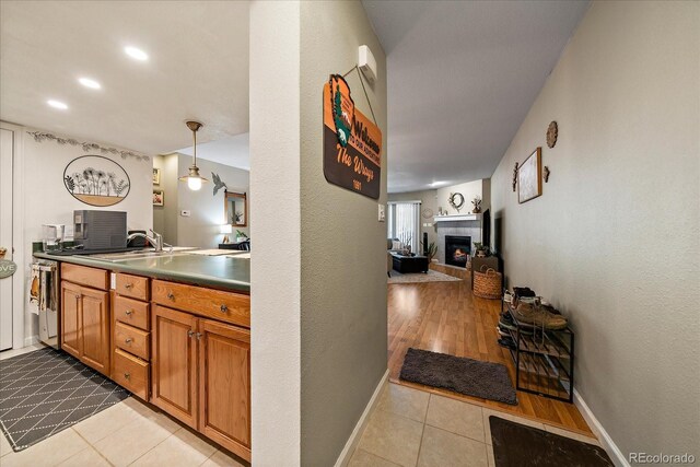 23712 Pondview Pl Unit A, Golden, CO 80401 - kitchen with light tile patterned floors, a fireplace, brown cabinetry, open floor plan, and decorative light fixtures