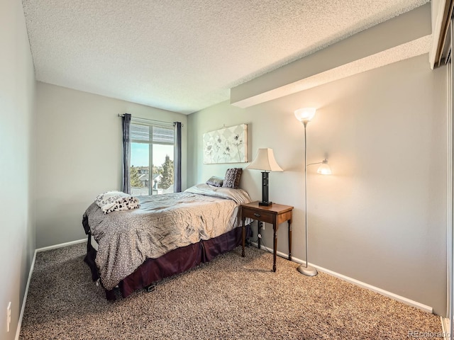 bedroom with carpet floors, baseboards, and a textured ceiling