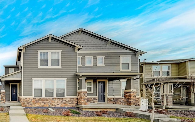 craftsman-style house featuring a porch and stone siding