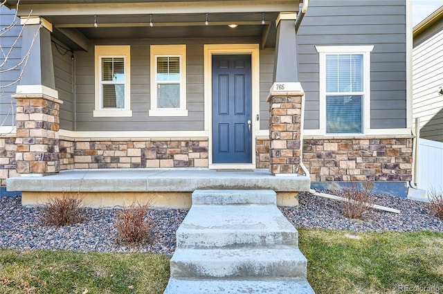 property entrance featuring covered porch and stone siding