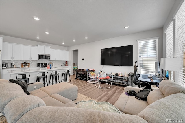 living area featuring light wood finished floors and recessed lighting