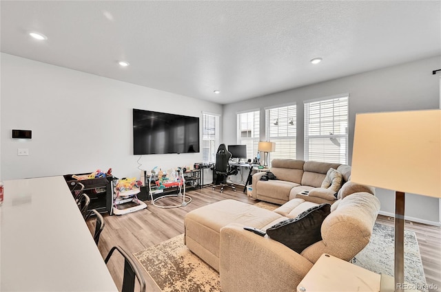 living area featuring recessed lighting, wood finished floors, and a textured ceiling