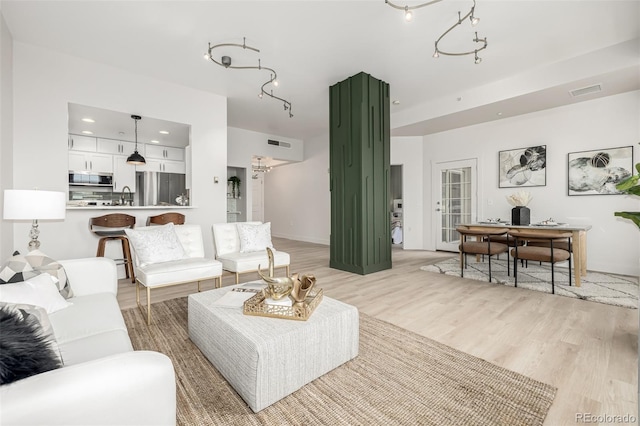 living room with light wood-type flooring and sink