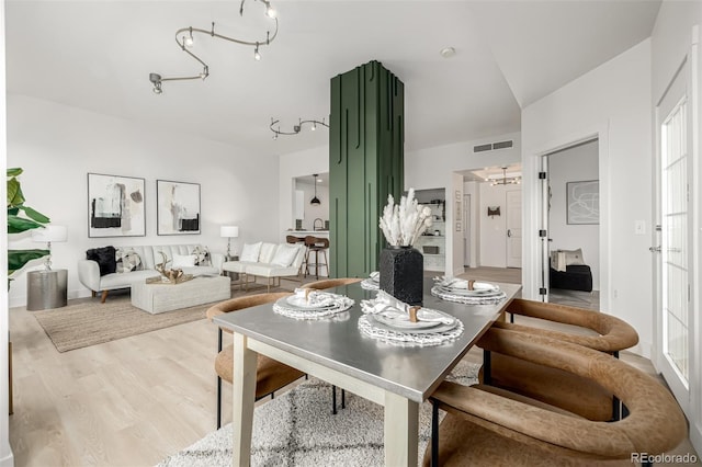 dining room with wood-type flooring, french doors, and lofted ceiling