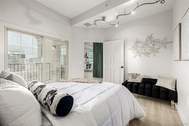 bedroom featuring access to exterior and light wood-type flooring